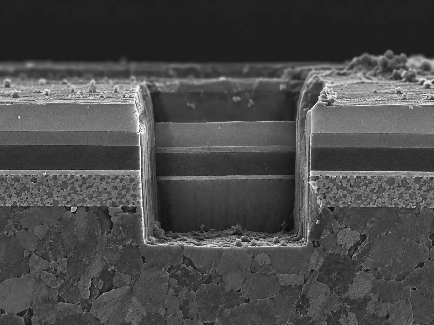 FIB cross-section showing site-specific milling and exposed multilayer material interface